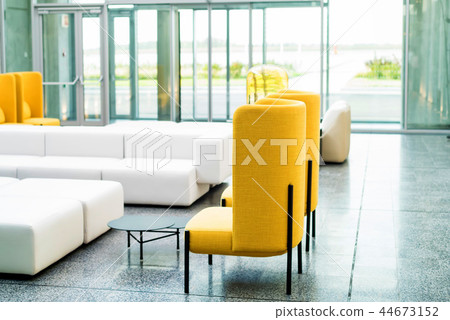 Office waiting area interior with white sofas and yellow chairs 44673152