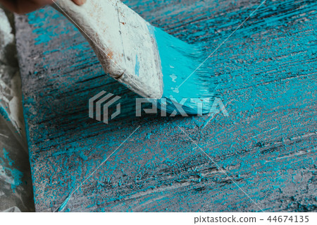 closeup hand use brush paint white blue on surface 44674135