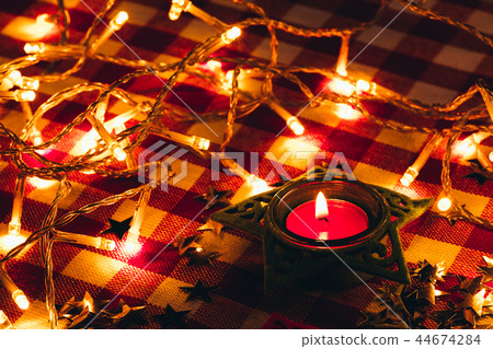 candle and garland lights in the background candle and garland lights in the background 44674284