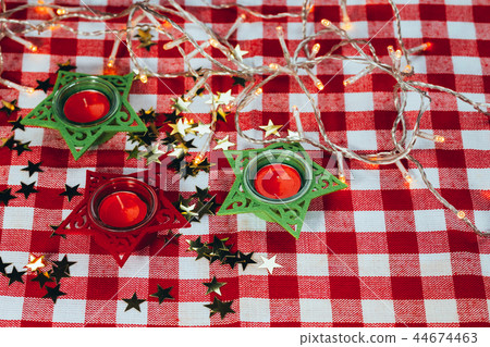 candle on red checkered tablecloths and garland 44674463