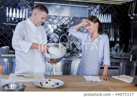 Tired young lady looking at the chefs work Tired young lady looking at the chefs work 44675157