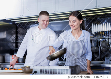 Young lady following chefs advice and cooking Young lady following chefs advice and cooking 44675197