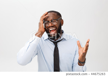 Portrait of desperate annoyed black male screaming in rage and anger tearing his hair out while Portrait of desperate annoyed black male screaming in rage and anger tearing his hair out while 44675263