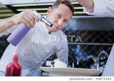 Experienced cook cooking a new dish in the kitchen Experienced cook cooking a new dish in the kitchen 44675264