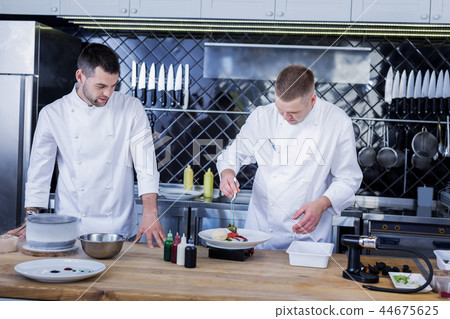 Young cooks working in the kitchen together 44675625