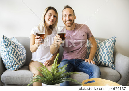 Relaxed young couple watching tv and drinking beer at home 44676187