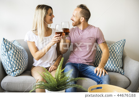 Relaxed young couple watching tv and drinking beer at home 44676188