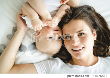 mother with baby on bed having good time 44676815