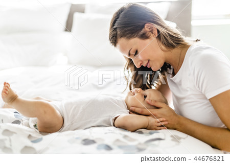 mother with baby on bed having good time 44676821