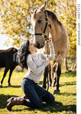 A Portrait of young beautiful woman with brown horse outdoors 44677272