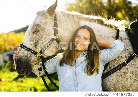 A Beautiful teen girl on the farm with her horse. A Beautiful teen girl on the farm with her horse. 44677883