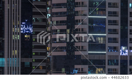 Windows of the multi-storey building of glass and steel lighting inside and moving people within timelapse Windows of the multi-storey building of glass and steel lighting inside and moving people within timelapse 44682633