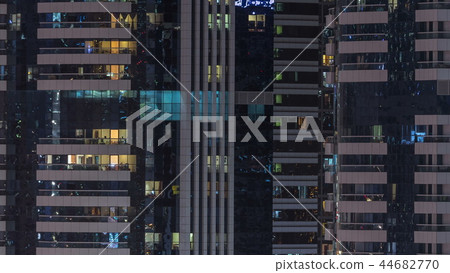 Windows of the multi-storey building of glass and steel lighting inside and moving people within timelapse Windows of the multi-storey building of glass and steel lighting inside and moving people within timelapse 44682770