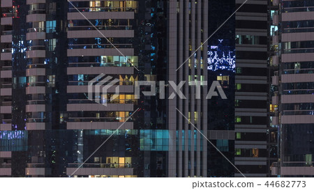 Windows of the multi-storey building of glass and steel lighting inside and moving people within timelapse Windows of the multi-storey building of glass and steel lighting inside and moving people within timelapse 44682773