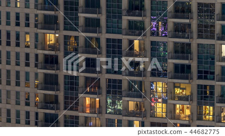 Windows of the multi-storey building of glass and steel lighting inside and moving people within timelapse Windows of the multi-storey building of glass and steel lighting inside and moving people within timelapse 44682775