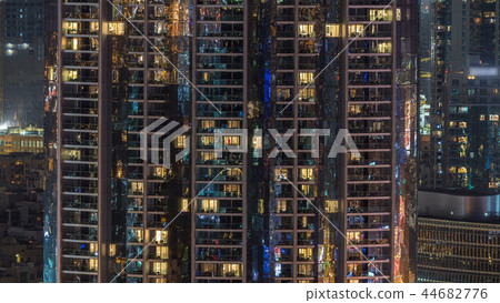 Windows of the multi-storey building of glass and steel lighting inside and moving people within timelapse Windows of the multi-storey building of glass and steel lighting inside and moving people within timelapse 44682776