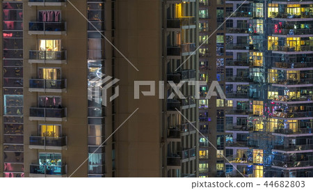 Windows of the multi-storey building of glass and steel lighting inside and moving people within timelapse Windows of the multi-storey building of glass and steel lighting inside and moving people within timelapse 44682803