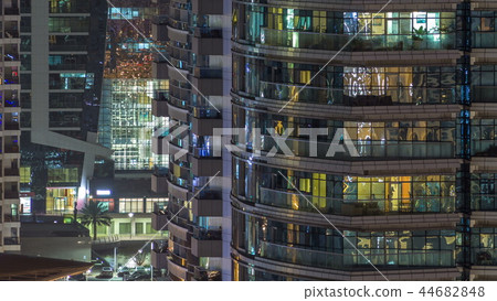 Windows of the multi-storey building of glass and steel lighting inside and moving people within timelapse Windows of the multi-storey building of glass and steel lighting inside and moving people within timelapse 44682848