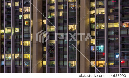 Windows of the multi-storey building of glass and steel lighting inside and moving people within timelapse Windows of the multi-storey building of glass and steel lighting inside and moving people within timelapse 44682990