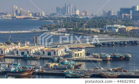 Dubai creek landscape timelapse with boats and ship in port and modern buildings in the background during sunset 44682992