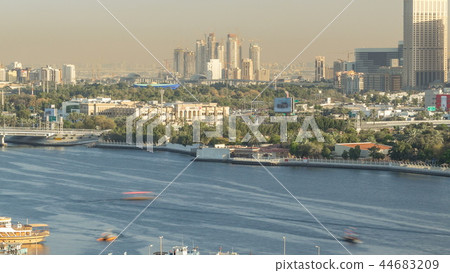 Dubai creek landscape timelapse with boats and ship in port and modern buildings in the background during sunset 44683209