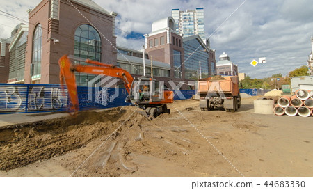 Industrial excavator loading soil material from road construction site into a dumper truck timelapse Industrial excavator loading soil material from road construction site into a dumper truck timelapse 44683330
