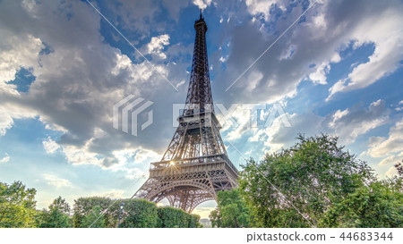 The Eiffel tower with warm rays of light in clouds during sunset timelapse hyperlapse. The Eiffel tower with warm rays of light in clouds during sunset timelapse hyperlapse. 44683344