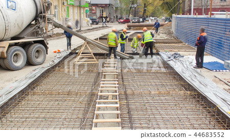 Concrete works for road maintenance construction with many workers and mixer timelapse 44683552