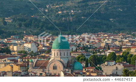 Synagogue of Florence timelapse with green copper dome rising above surrounding suburban housing with green hillside behind Synagogue of Florence timelapse with green copper dome rising above surrounding suburban housing with green hillside behind 44687457