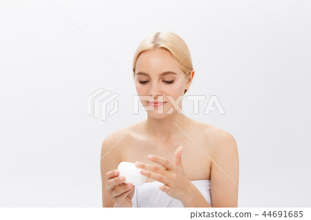 Close up beauty portrait of a laughing beautiful half naked woman applying face cream isolated over 44691685