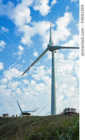 An upright towering wind turbine windmill sightseeing spot blue good angle green light green energy 44691904