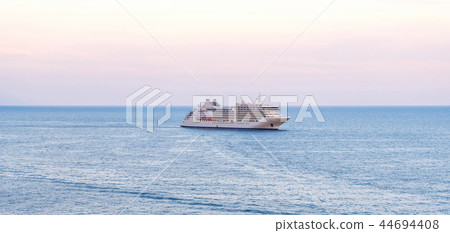 Passenger ship cruising on water at sunset 44694408