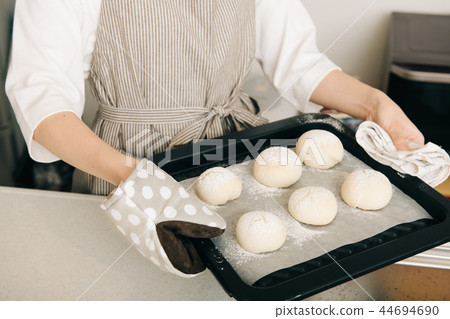 Hand made young woman hand holding a baking sheet 44694690