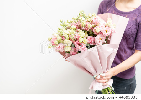 beautiful spring bouquet. Young girl holding a flowers arrangement with lisianthus of pink colors 44695335