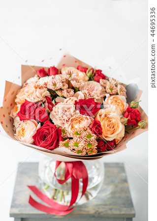 beautiful spring bouquet. flowers arrangement with various of colors in glass vase on old table 44695336
