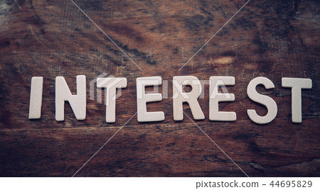 The word "INTEREST" is arranged from a wooden The word "INTEREST" is arranged from a wooden 44695829