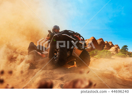 Quad bike rider climbing the sands, front view Quad bike rider climbing the sands, front view 44696240