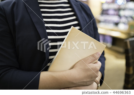 男子在一家咖啡館拿一本書 男子在一家咖啡館拿一本書 44696363
