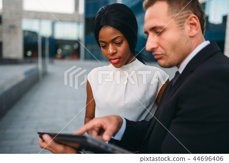 Business woman and businessman looks on laptop 44696406