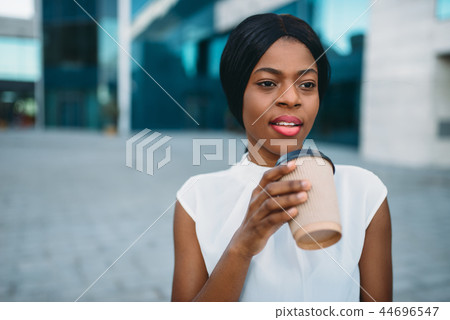 Business girl grinks coffee from cardboard cup Business girl grinks coffee from cardboard cup 44696547