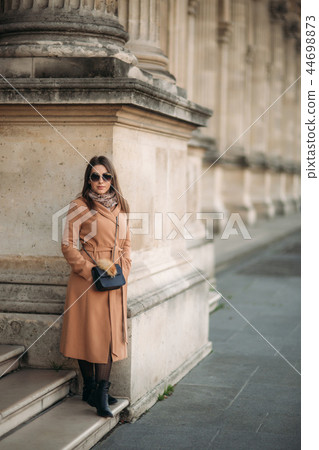 Stylish girl in coat posing for photographer 44698873