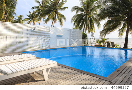 Blue swimming pool with coconut tree. 44699337