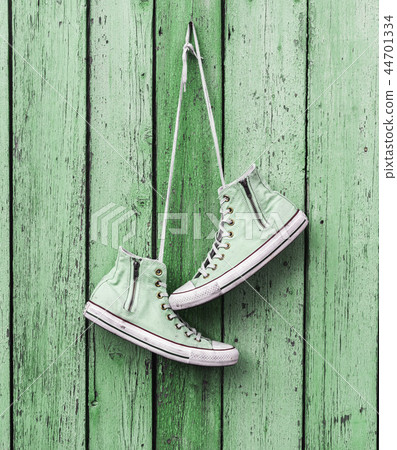 worn old textile shoes hang on a nail worn old textile shoes hang on a nail 44701334