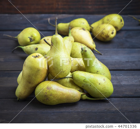ripe green pears on a brown wooden background 44701336