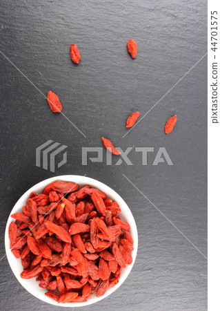 dried goji berries in a small white bowl dried goji berries in a small white bowl 44701575