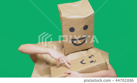 concept of emotions, gestures. man with a package on his head, with a painted emoticon, smile, joy concept of emotions, gestures. man with a package on his head, with a painted emoticon, smile, joy 44702886