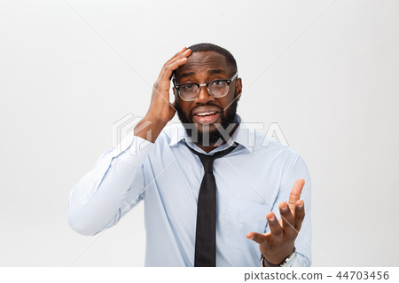 Portrait of desperate annoyed black male screaming in rage and anger tearing his hair out while Portrait of desperate annoyed black male screaming in rage and anger tearing his hair out while 44703456
