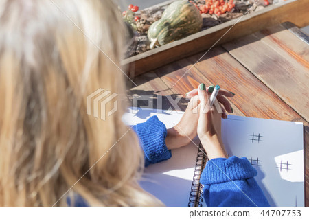 Pensive woman with pen at the table Pensive woman with pen at the table 44707753