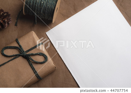Empty page and a gift tied with green cord Empty page and a gift tied with green cord 44707754