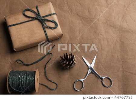 Gift in brown paper with string and scissors Gift in brown paper with string and scissors 44707755
